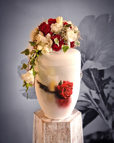 Urne auf Traueralter mit Blumenschmuck