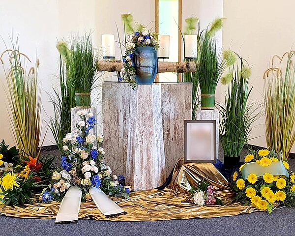 Urne auf Traueralter mit Blumenschmuck