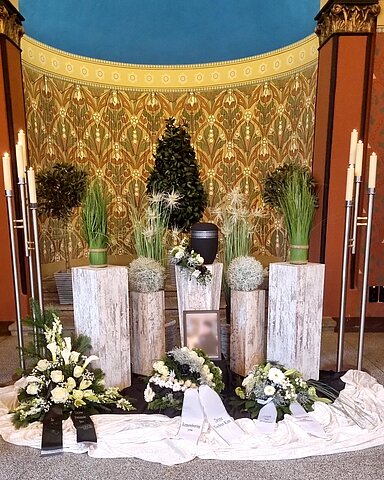 Urne auf Traueralter mit Blumenschmuck